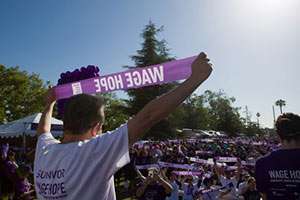 Two-year survivor Nester Gomez leads the WAGE HOPE rallying cry from the PurpleStride Los Angeles stage.