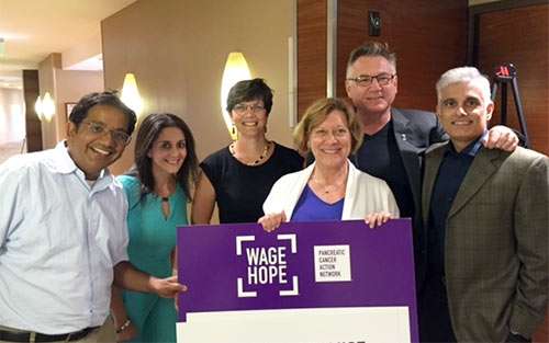 Lynn Matrisian, PhD, MBA, holding sign, with scientific advisors who Wage Hope every day.