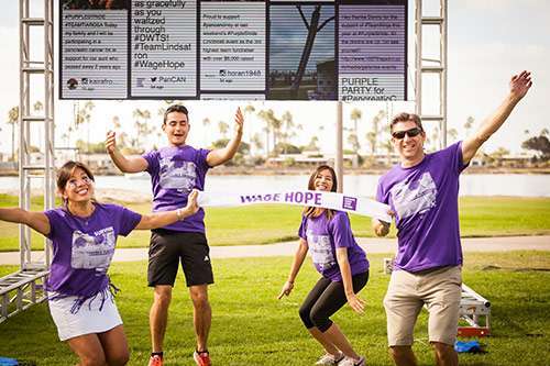 Anggie jumping for joy with her family at PurpleStride San Diego. 