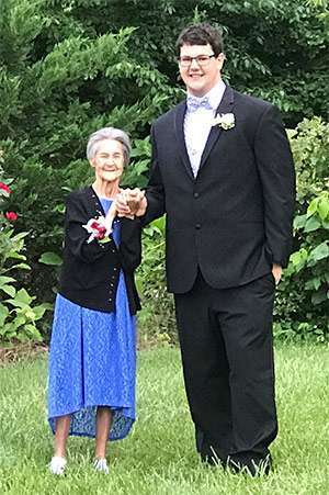 High school junior, Stephen Virgil, holds the hand of his 92-year old grandmother, Julie Jarman, for their prom picture.