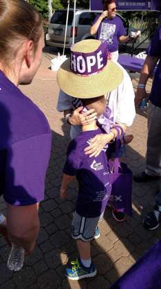 Six-year old son of father who lost his dad to the disease hugs a pancreatic cancer survivor at Cleveland walk/run event.