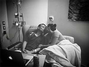 Jennifer bedside kissing her husband during chemo treatment in hospital