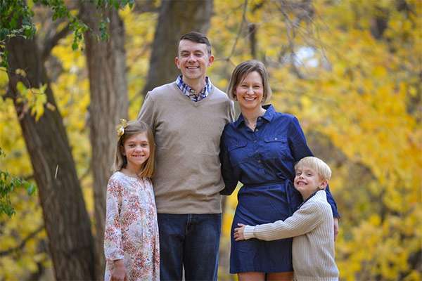 Oncologist Mark Lewis, MD, with his wife and children amidst fall foliage.