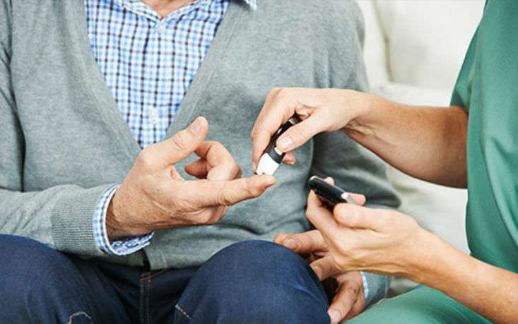 Man having his finger pricked to test for blood glucose.