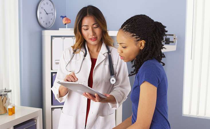 A doctor and patient discussing a treatment plan in the physician’s office.