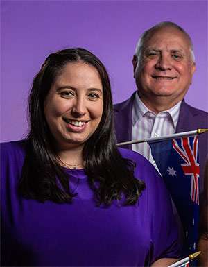 Daughter and father hold Australia flags.