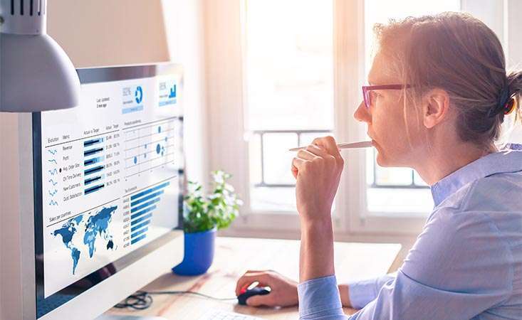 Woman is reviewing global cancer statistics and charts on her computer.