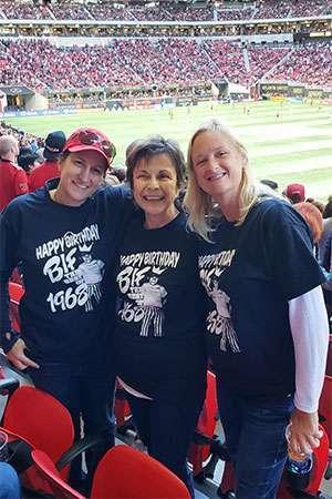 Pancreatic cancer survivor and volunteer with friends at a soccer game. 