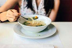 A bowl of soup filled with vegetables provides a flavorful, low-fat, fast-food option