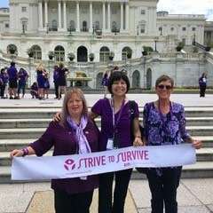 Three female pancreatic cancer survivors hold “strive to survive” sign at the Capitol building.