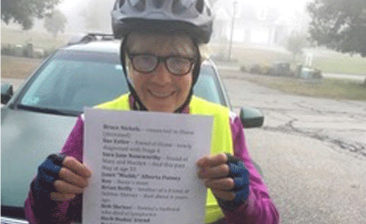 Cyclist holds list of pancreatic cancer supporters as she finishes 106-mile ride to raise funds