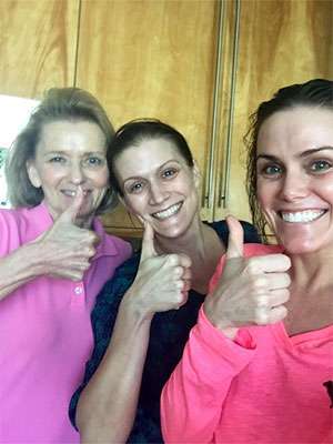 Pancreatic cancer patient (middle) with her mother and sister giving thumbs-up after treatment