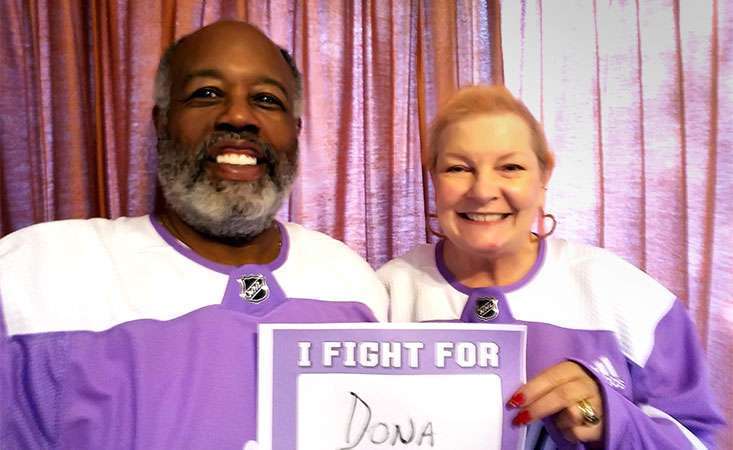 Husband and wife wearing Hockey Fights Cancer jerseys as she battles pancreatic cancer