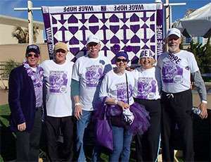 Pancreatic cancer survivors in front of quilt made by a survivor at PurpleStride Virginia Beach