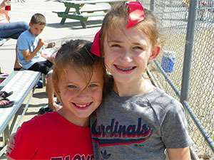 Girls when they were younger together at a baseball tournament