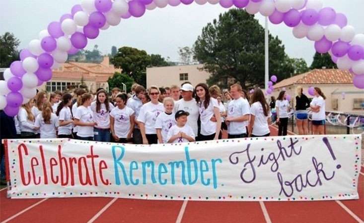 High school student at teen cancer fundraising walk with her coach, a cancer survivor