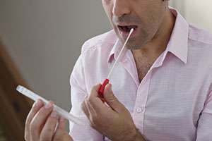 Man gives saliva sample for genetic testing to determine his pancreatic cancer risk. 