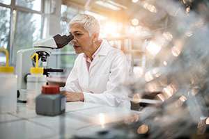 A pathologist looks at a biopsy under a microscope to make a clear pancreatic cancer diagnosis.