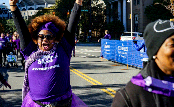 Participant celebrates crossing finish line at 5k walk in Charlotte to end pancreatic cancer