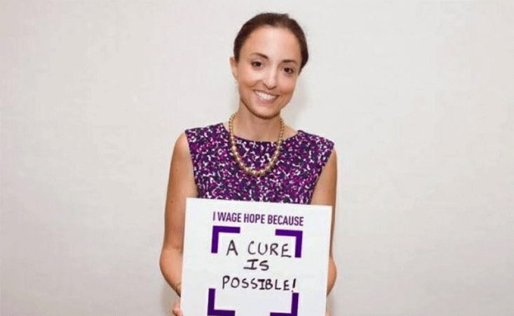 A pancreatic cancer advocacy volunteer in Jacksonville holds a Wage Hope sign to find a cure