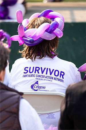A pancreatic cancer survivor listens to fellow survivors give speeches at 5K walk in Sacramento