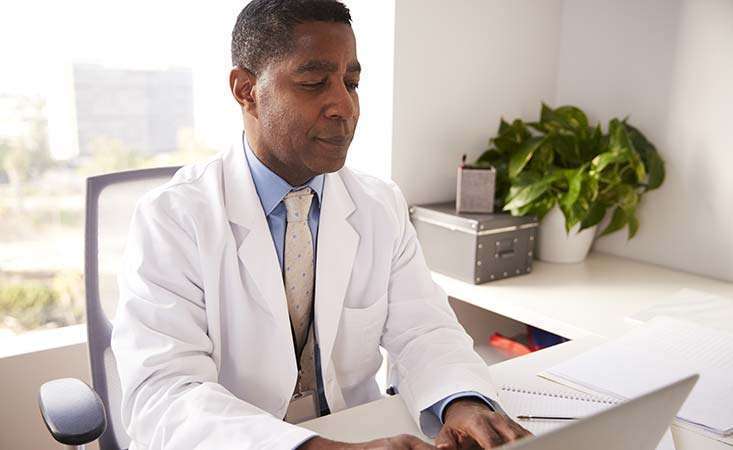 African-American male doctor assesses a patient’s risk for developing pancreatic cancer