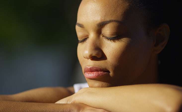 Pancreatic cancer caregiver takes a moment for self-care to meditate outside