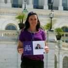 Advocacy Day volunteer at U.S. Capitol with photo of parents who died from pancreatic cancer