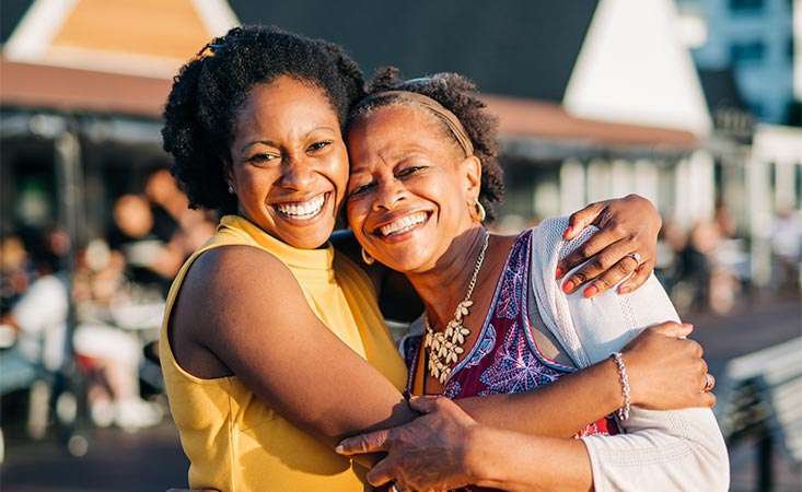 Mother, a pancreatic cancer survivor, smiling and hugging her daughter, a PanCAN volunteer