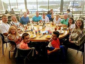 Family of stage IV pancreatic cancer survivor enjoys dining together at a dockside restaurant