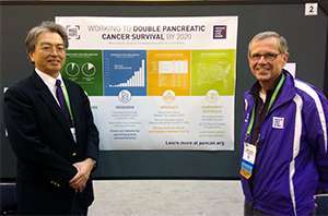13-year survivor presenting pancreatic cancer awareness work with colleague at scientific event