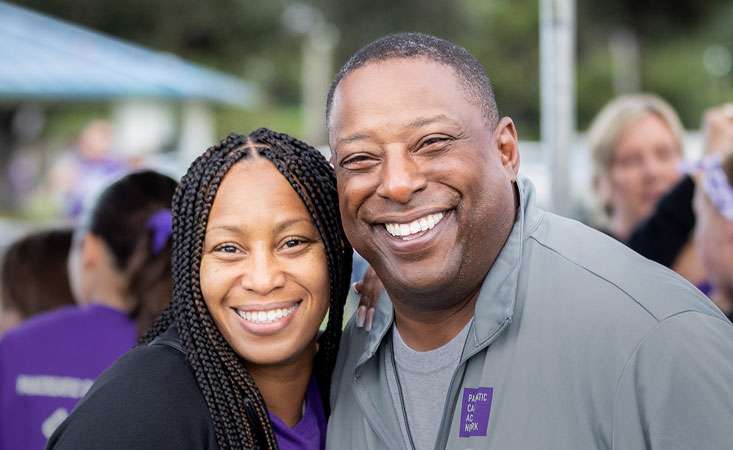 Male and female fundraising volunteers smiling at camera.