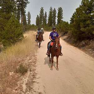 Two PurpleStride participants ride their horses.