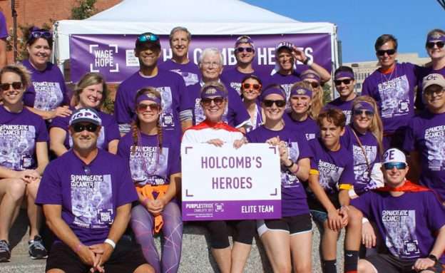 Stage 4 pancreatic cancer survivor with friends and family at PanCAN PurpleStride event