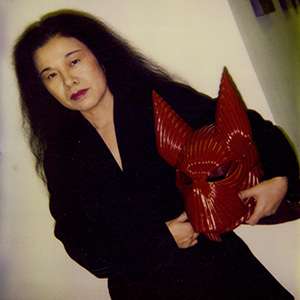 Eiko Ishioka holding a red costume piece from the movie The Cell.