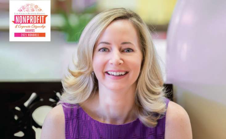 Middle-aged Caucasian businesswoman smiling at camera.