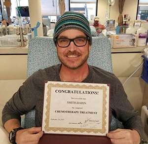 50 year old Caucasian man showing plaque indicating he finished all his chemo