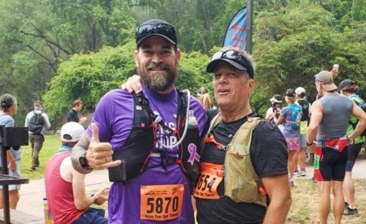 Two middle-aged Caucasian males outside in running gear after a race.