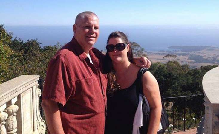 Father and daughter pose for photo overlooking the ocean