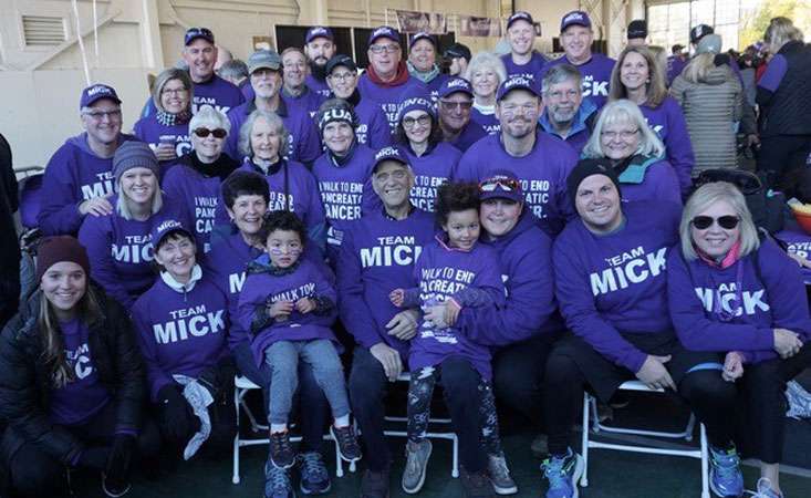 Group wearing purple sweatshirts saying Team Mick on them at PanCAN PurpleStride.