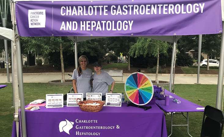 Charlotte Gastro employees in their booth at PanCAN PurpleStride