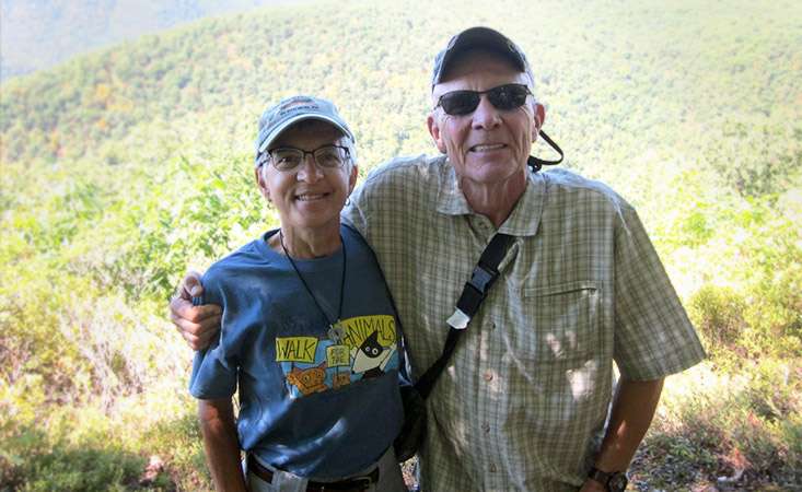 Couple posing for photo with forest as background