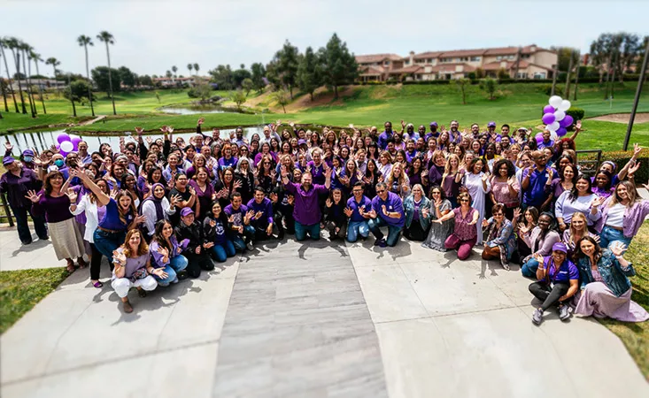 Around 150 staff members of the Pancreatic Cancer Action Network posing for a group shot outdoors in the sun