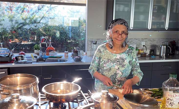 Syeda "Naz" Nazar cooking in her kitchen.