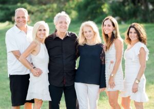 Six members of the Weinstein family: mom, dad, son-in-law, and three daughters smiling.